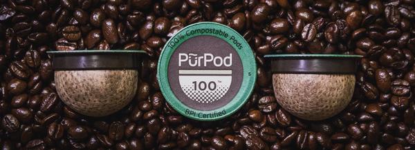 Image of Pur Pod single serve compostable placed on coffee beans